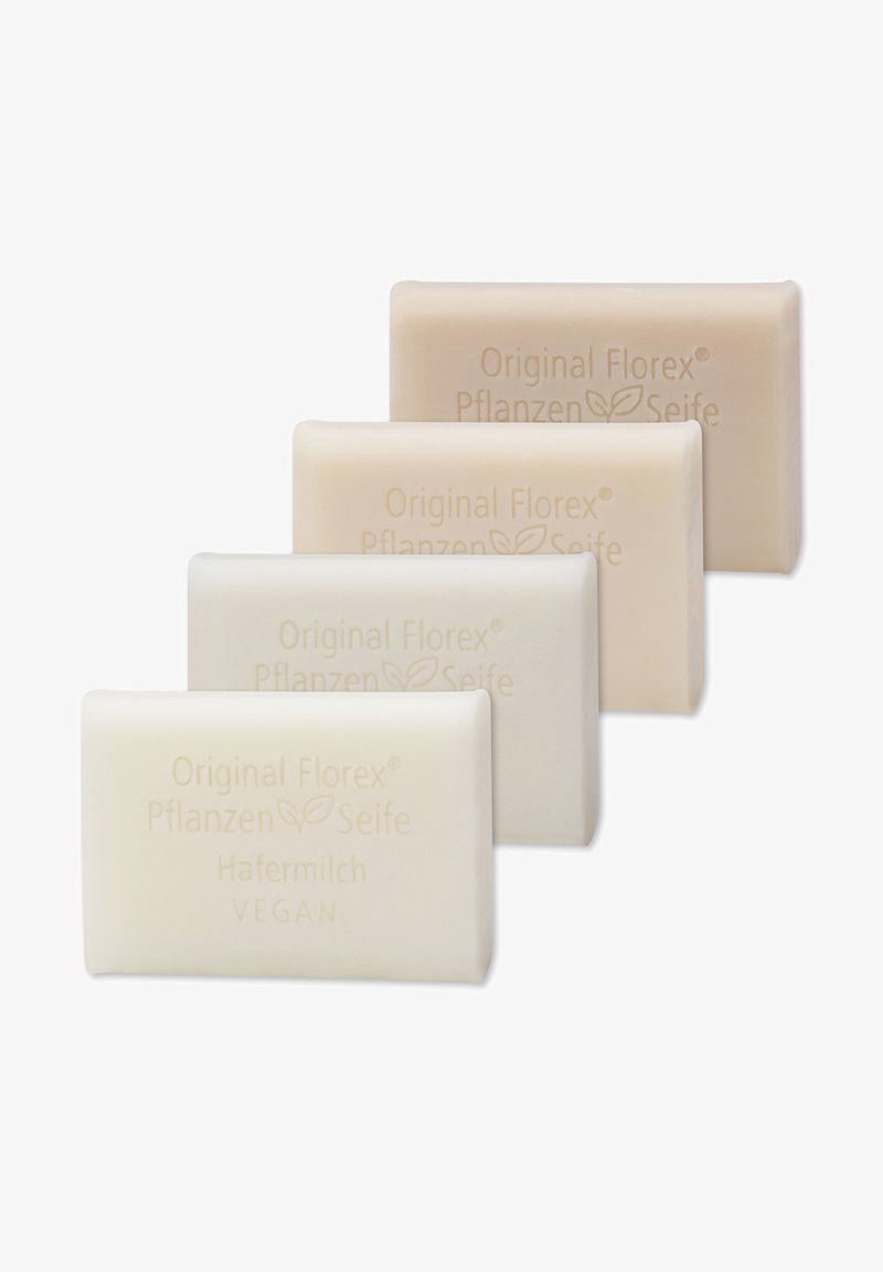 Four rectangular bars of soap in varying shades of light cream and beige. Textured surface with embossed branding, labeled "Vegan" and "Hafermilch."