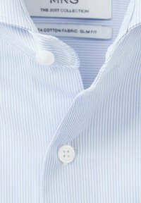 Svetlomodrá pásikavá košeľa s bielymi gombíkmi vyrobená z bavlneného materiálu. Má priliehavý strih a klasický golier. Viditeľná visačka s informáciou o možnosti prania v práčke.