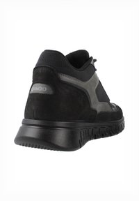 Scarpe sportive nere caratterizzate da un mix di camoscio e tessuto testurizzato, con un tacco arrotondato e una suola in gomma con motivo. Accenti grigi sui lati.