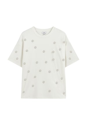 T-shirt blanc à manches courtes avec des pois décoratifs gris disposés uniformément sur le devant, avec un col rond et une coupe décontractée.