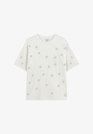 T-shirt blanc à manches courtes avec des pois décoratifs gris disposés uniformément sur le devant, avec un col rond et une coupe décontractée.