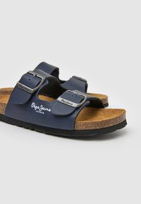 Tamno plave sandale s dva podesiva remena, srebrnim kopčama, plutenom uloškom i crnom gumenom potplatom s imenom marke "Pepe Jeans."