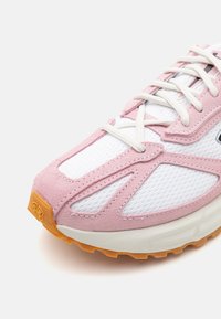Scarpa da corsa leggera con tomaia in suede rosa e rete bianca, punta rinforzata e suola in gomma arancione resistente per la trazione.