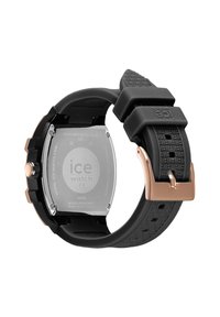 Orologio in gomma nera con cinturino testurizzato e dettagli in oro rosa. Il fondello in acciaio inossidabile presenta un logo inciso. Design audace e sportivo.