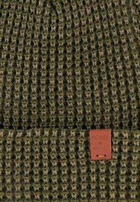 Włóczkowa czapka w ciemnozielonym kolorze z textured stitching. Posiada brązową skórzaną metkę z wytłoczonym napisem "Bickley + Mitchell."