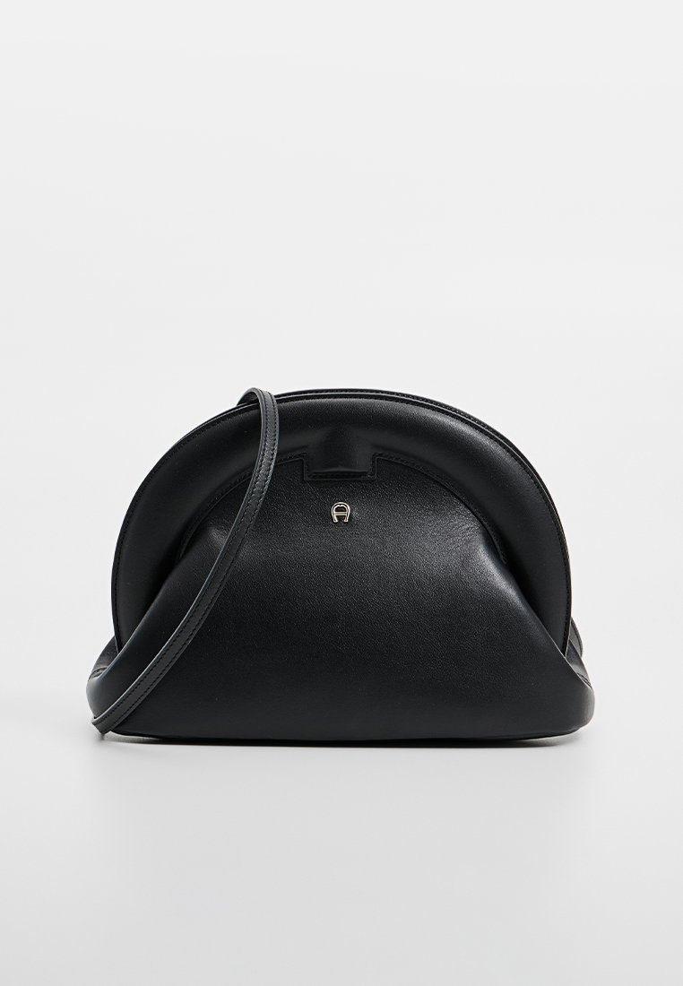 Schwarze Lederhandtasche mit runder Form, ausgestattet mit einem Vorderverschluss, gebogenem Oberteil und einem verstellbaren Tragegurt. Glatte Textur mit dezentem Glanz.