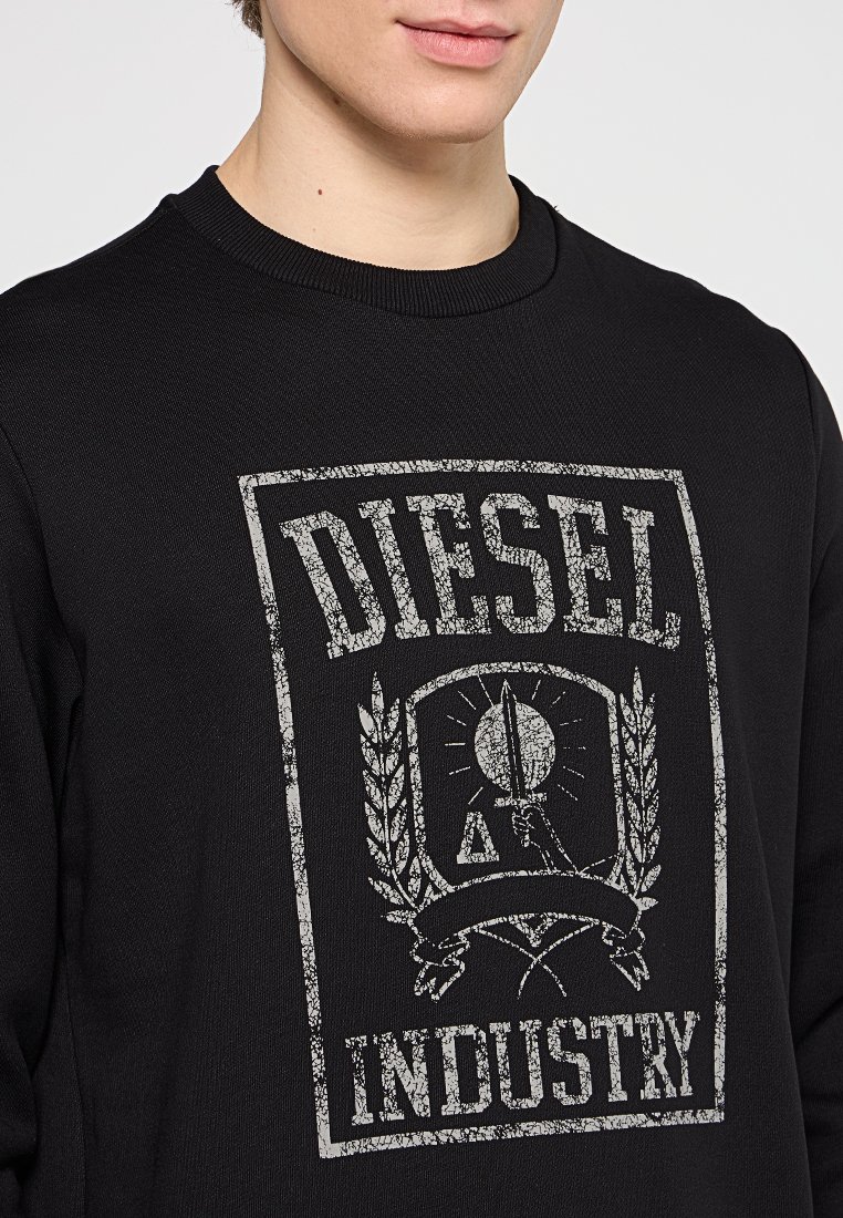 Felpa nera realizzata in cotone, con una stampa grafica testurizzata bianca che presenta la scritta "DIESEL" e "INDUSTRY", circondata da motivi di alloro.