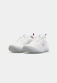 Weiße Sportschuhe mit einer strukturierten Netz-Oberfläche, Gummisohle und Logo-Akzenten. Verfügt über ein Schnürdesign und einen gepolsterten Kragen.