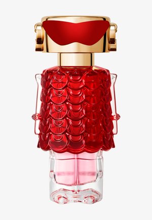 Transparent perfume bottle shaped like a person with a red scale-textured dress and gold cap resembling sunglasses and headphones.