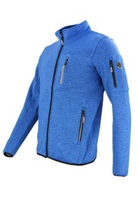 Giacca in pile blu con colletto alto, zip frontale completa, due tasche anteriori e una tasca sul petto. Presenta una texture a macchie scure.