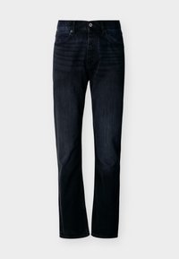 Σκούρα μπλε-ίντιγκο τζιν με ίσιο κόψιμο, μπροστινό κούμπωμα με κουμπιά και φερμουάρ, θηλιές για ζώνη και πεντατσέπια, απεικονίζεται σε απλό ανοικτό φόντο.