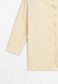 Cream-colored long sleeve cardigan with ribbed cuffs and hem, buttoned front, displayed on white background.