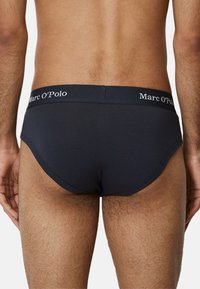 Czarne męskie slipy wykonane z miękkiego materiału, z dopasowanym krojem, elastycznym pasem z logo "Marc O’Polo" oraz gładkimi detalami szwów.