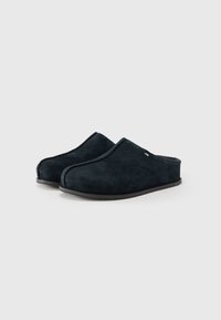 Pair of black suede slip-on slippers with closed toe and low heel on a white background.