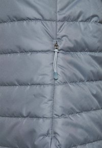 Gray padded jacket with horizontal stitching detail. Features a zippered pocket with a textured pull tab in light gray. Smooth fabric texture.