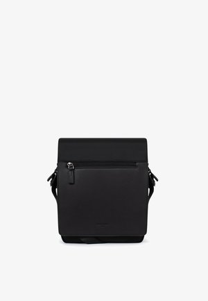 Zwarte leren crossbodytas met voorvak met ritssluiting, klepsluiting en verstelbare riem, rechtopstaand op een witte achtergrond.