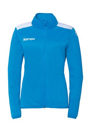 Blå sportsjakke lavet af letvægtsstof. Har hvide accenter på skuldrene og en lynlås foran. Logoet er trykt på brystet.