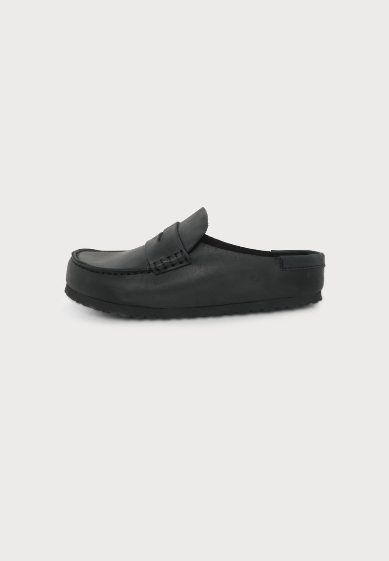 Μαύρο δερμάτινο παπούτσι τύπου slip-on με ραφή moc toe και ακάλυπτη φτέρνα, εμφανισμένο σε απλό ανοιχτό φόντο.