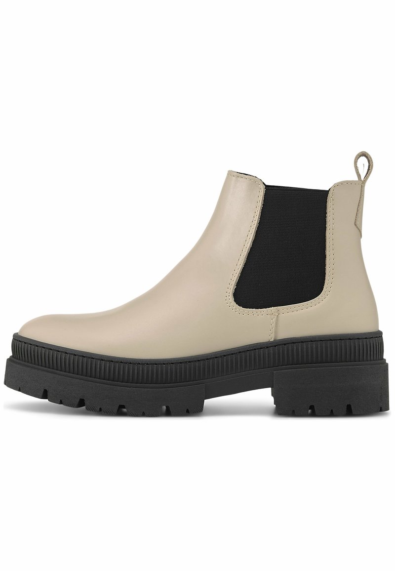 Béžové kožené Chelsea boty s černou elastickou boční částí, texturovanou podrážkou a úchytem. Zaoblená špička a robustní, drsný spodní část.
