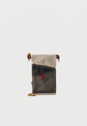 Mała beżowo-czarna siateczkowa saszetka z czerwoną metką i kolorowymi pętlami do ściągania w górnych narożnikach i dolnej krawędzi.