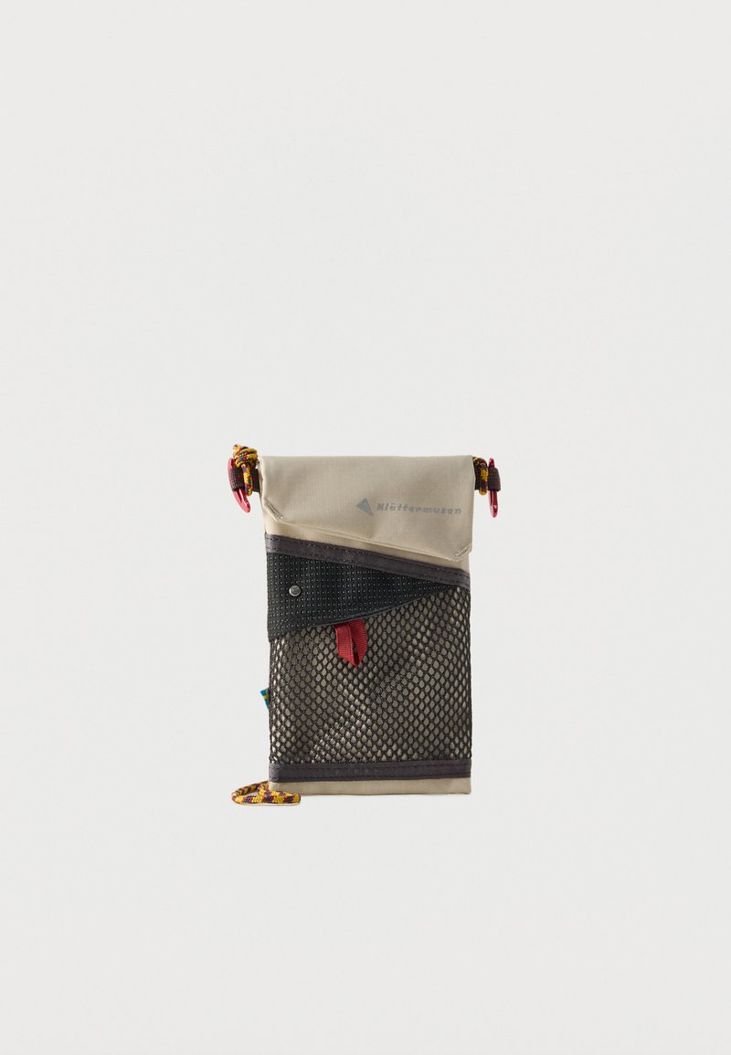 Μικρό μπεζ και μαύρο δίχτυ πουγκί με κόκκινη ετικέτα και πολύχρωμες θηλιές κορδονιών στις πάνω γωνίες και στην κάτω άκρη.