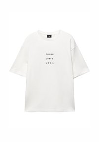 Witte t-shirt met korte mouwen van katoen, met de tekst "DENK BEPERK LOOS" in het zwart, verticaal gecentreerd. Ronde hals.