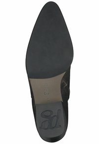 Černá kožená bota s špičatou špičkou, hladkým svrškem a nízkým gumovým podpatkem. Obsahuje embosované logo na podrážce a minimální detaily šití.