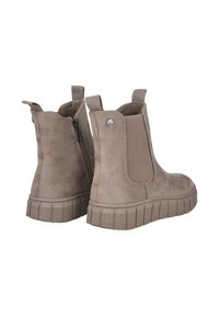 Botas de tobillo de ante beige con paneles laterales elásticos, bucles traseros y una suela de goma texturizada con un patrón estriado. Detalle de cremallera en el costado.