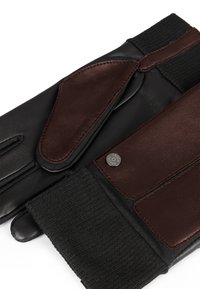 Guanti in pelle con una combinazione di colori nera e marrone, polsino a coste e dettagli con bottone tattile per la compatibilità con il touchscreen.