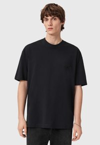 Sort kortærmet bomuld t-shirt med rund hals, der har et præget logo på venstre brystlommeområde. Struktureret pasform.