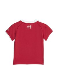 Röd t-shirt med kort ärm, vit krage och axelaccenter. Har en liten logotyp och siffran "97" tryckt i vitt på baksidan. Strukturerad tyg.