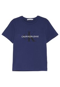 Camiseta de algodón azul marino con cuello redondo y mangas cortas. Presenta un logo blanco "CALVIN KLEIN JEANS" y un diseño negro destacado "CK".
