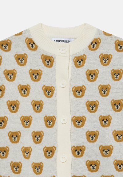 Крем cardigan с копчета с повторящ се модел на малки кафяви мечешки лица на светъл фон.