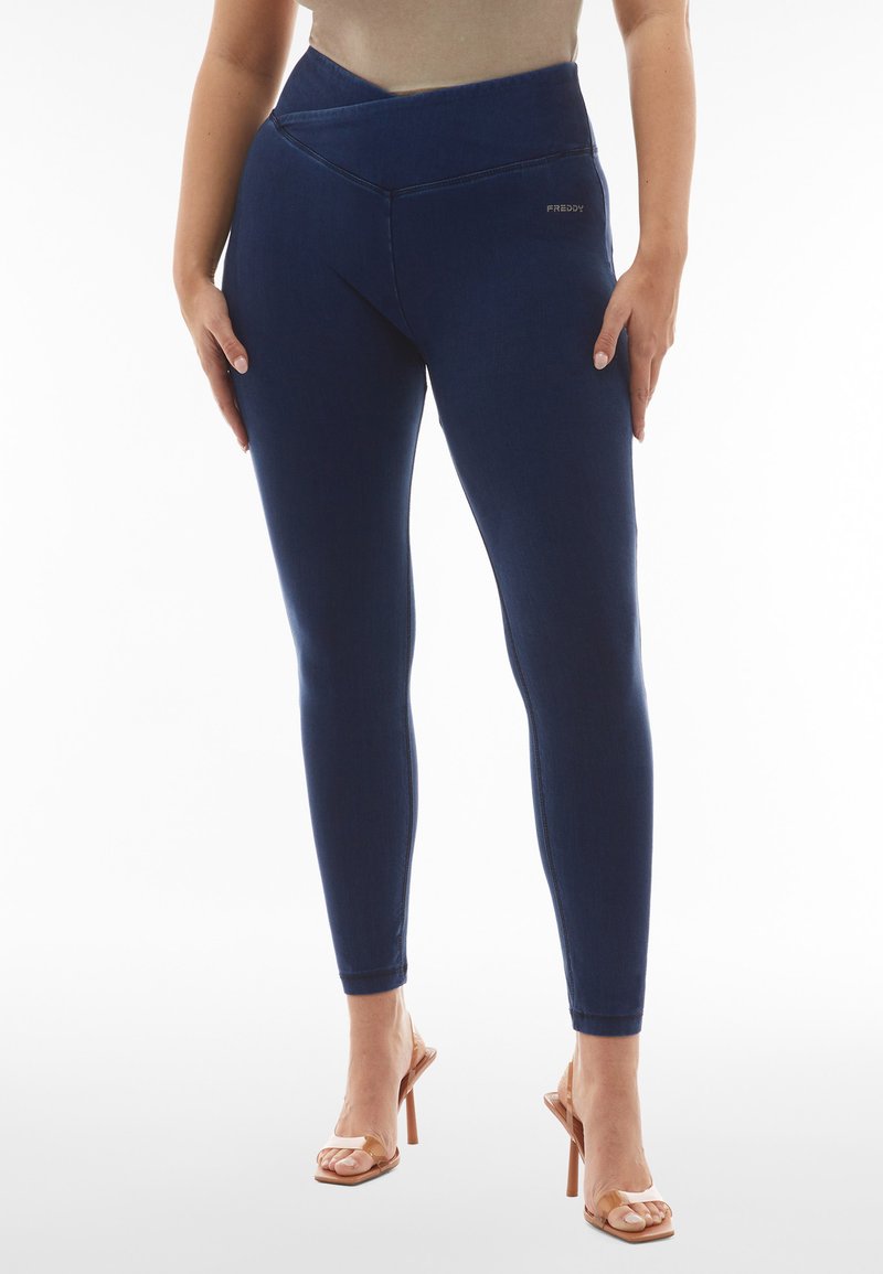 Leggings azul marino hechos de una tela elástica con una cinturilla cruzada alta, con costuras a tono y un pequeño logotipo cerca de la cadera.