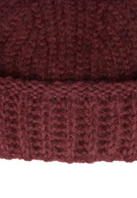 Strikket lue i dyp burgunder, med et teksturert mønster og ribbekant. Laget av myk, loete ull for varme og komfort.