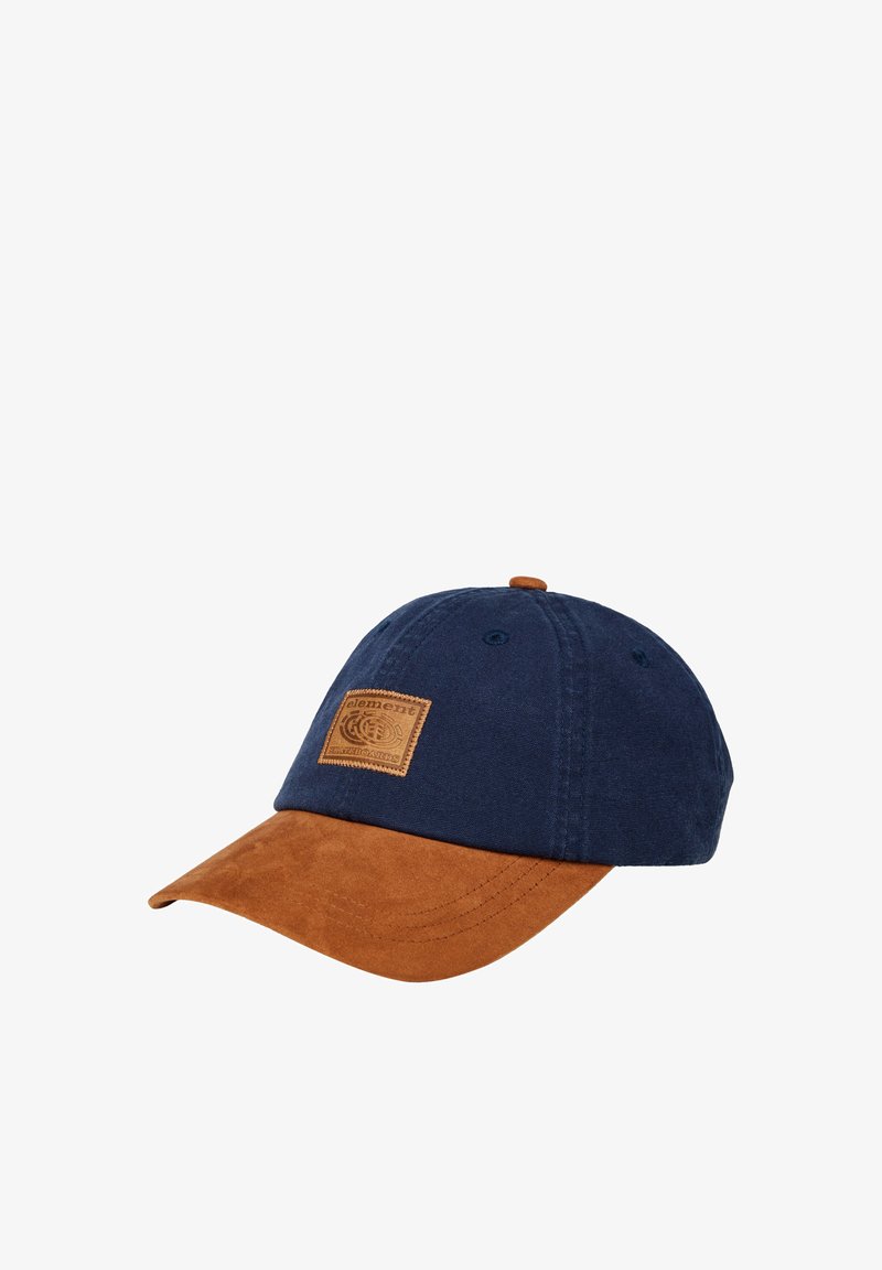 Marineblauwe katoenen pet met een bruin suède klep, voorzien van een gestructureerde bruine leren patch aan de voorkant met reliëf logo-details.