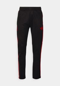Black track pants made of smooth fabric, featuring red side stripes and a small red logo on the left thigh. Elastic waistband for comfort.