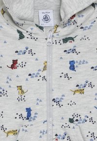 Felpa grigia con zip, caratterizzata da motivi giocosi di animali e geometrici in rosso, blu, giallo e verde, realizzata in tessuto morbido.