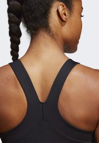 Zwart sport tanktop met een Y-vormig rugontwerp, gemaakt van gladde stof. Heeft een subtiele naaddetails langs de rug.