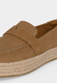 Mocassin en daim fauve avec semelle plateforme en jute tressée et détail de bride cousue sur le dessus.