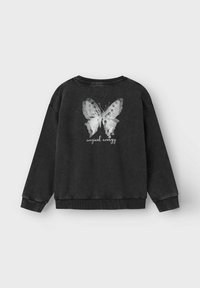 Sweatshirt noir avec un design de papillon blanc à l'arrière, accompagné du texte "énergie magique" en dessous. Fabriqué en matière douce, coupe décontractée.