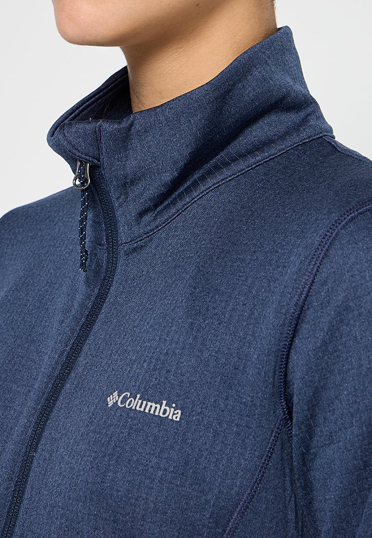 Navyblauwe ritsjack gemaakt van gestructureerde stof. Voorzien van een hoge kraag en Columbia-logo in het wit op de borst.
