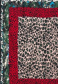 Tejido de estampado de leopardo con una base rosa, manchas negras y verdes, bordeado por bordes con patrones rojos y verdes. Superficie suave y texturizada.