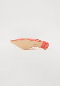 Stivale in pelle verniciata corallo con punta affusolata e tacco sottile, caratterizzato da una suola beige e un sottile accento metallico sul tacco.