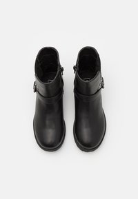 Černé kožené kotníkové boty s hladkým povrchem, zdobené dekorativní sponou na boku a nízkou, strukturovanou solí.