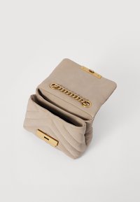 Beige lædertaske med quiltet design, guldfarvet metal og kæde. Åbent top der viser interiøret med ét rum og lås.