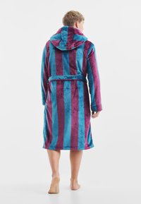 Kapturazowy szlafrok z miękkiego, puszystego materiału w naprzemiennych pionowych paskach w kolorze turkusowym i ciemnego burgunda, z zawiązywanym paskiem i długimi rękawami.