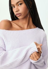 Ljuslila, ribbad stickad tröja med off-shoulder-design och långa ärmar, med en mjuk textur och avslappnad passform.