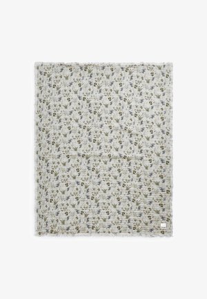 Kukkakuvioinen peitto, jossa on kevyt, teksturoitu kangas. Vihreitä, sinisiä ja ruskeita kukkia vaalean kermaisella taustalla. Ripsireunat. Neliön muoto.