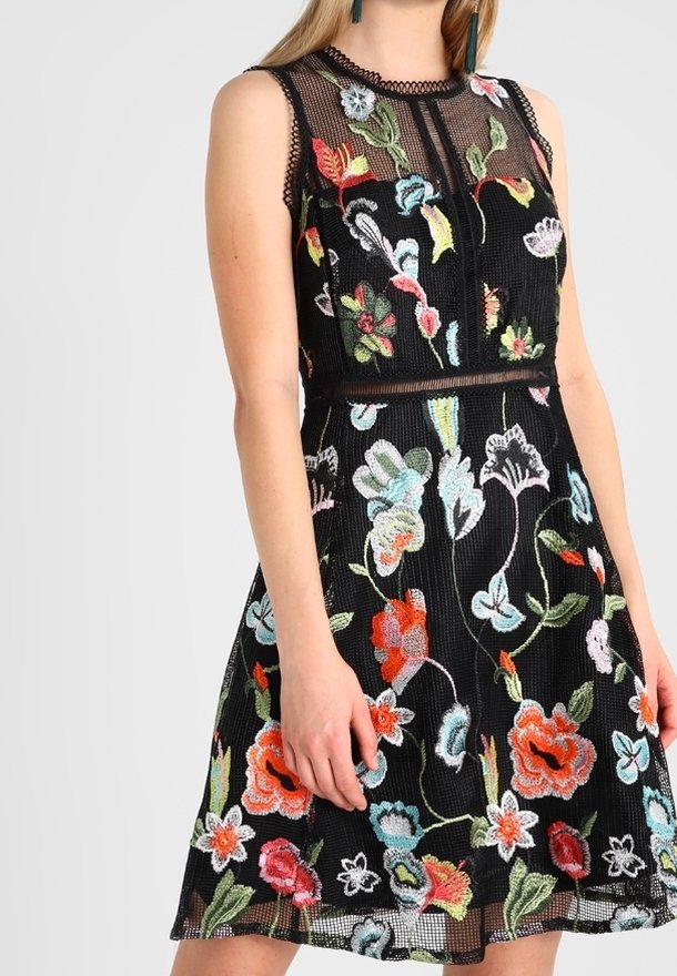 Czarna haftowana sukienka z dopasowanym gorsetem i rozkloszowanym dołem, ozdobiona kolorowymi kwiecistymi wzorami oraz teksturowaną siateczką na wierzchu.